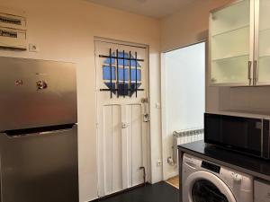 a kitchen with a washer and dryer next to a door at Maison conviviale in Villejuif