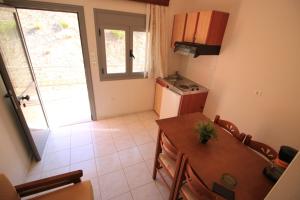a kitchen and dining room with a table and a refrigerator at Platis-Gialos apartments in Loutsa