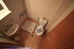 a small bathroom with a toilet and a sink at Platis-Gialos apartments in Loutsa