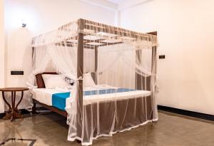 a bed with a canopy in a room at Villa Paddy Heaven in Unawatuna