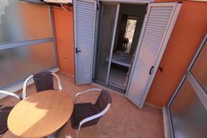 a balcony with a table and chairs and a mirror at Platis-Gialos apartments in Loutsa +20 photos