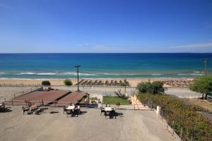 a view of a beach with a bench and the ocean at Platis-Gialos apartments in Loutsa