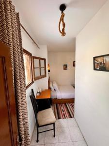 a small room with a desk and a bed at A private room by the rooftop in Cairo