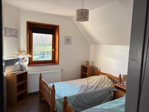 a bedroom with two beds and a window at Gîte LA ROUCHERIE bis in Lottinghen