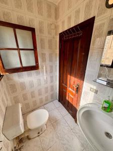 a bathroom with a toilet and a sink and a door at A private room by the rooftop in Cairo +16 photos