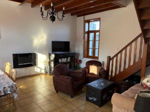 a living room with a couch and chairs and a tv at Gîte LA ROUCHERIE bis in Lottinghen