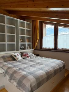 a bedroom with a large bed and a window at Bormio Urban Attic in Bormio