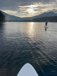 a person on a paddle board in the water at Elan Villa Nojiri in Shinano +2 photos