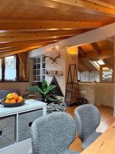 a living room with chairs and a table with a bowl of oranges at Bormio Urban Attic in Bormio +18 photos