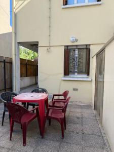 a red table and chairs in front of a building at Maison conviviale in Villejuif