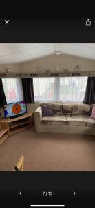 a living room with a couch and a flat screen tv at 162 Northfield, 3 bedroom, 8 berth in Beeford