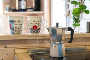 a blender sitting on a counter with three cups at Hausboot Baltic Goose in Burgtiefe auf Fehmarn 