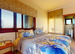 a bedroom with a bed with a blue and white bedspread at Villa Magic Sunset in Kyrenia +15 photos