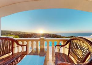 a balcony with two chairs and a view of the ocean at Villa Magic Sunset in Kyrenia