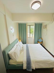 a bedroom with a bed and a window at POOLVIEW 2 bedrooms unit in Davao City