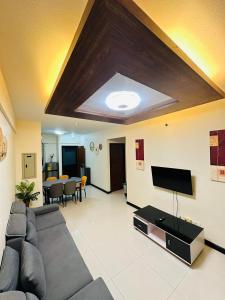a living room with a couch and a flat screen tv at POOLVIEW 2 bedrooms unit in Davao City