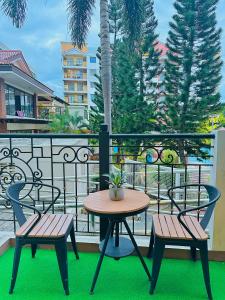 two chairs and a table on a balcony at POOLVIEW 2 bedrooms unit in Davao City