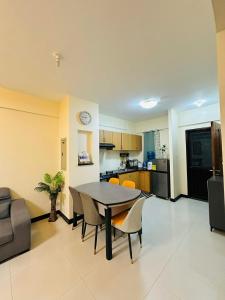 a kitchen and dining room with a table and chairs at POOLVIEW 2 bedrooms unit in Davao City