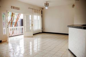 an empty room with a door and a tile floor at Welcome Inn Guest house in Kigali +13 photos
