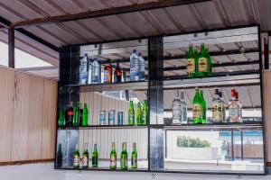 a shelf filled with different types of bottles at Welcome Inn Guest house in Kigali