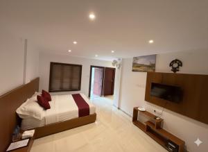 a bedroom with a bed and a flat screen tv at 1 Forest Soul - Forest Side Retreat with Pool in Batheri