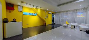 a woman sitting at a counter in a room with a yellow wall at Lemonade Hotel in Miri