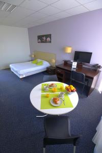 a hotel room with a table with food on it at KOSY Appart'Hôtels - Le Cours Moreau in Mâcon