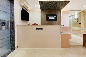 an office lobby with a reception desk with a sign on it at Townhouse Oak Ram Lala Mandir Kanpur Formerly Hotel Sun Rise in Kaliānpur