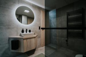 a bathroom with a sink and a mirror at Lake Forest Kabin in Bárdudvarnok