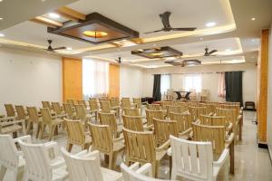 a room with a bunch of chairs and a table at Thai Residency - Opp to Bus Stand in Dhārāpuram