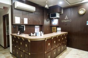 a waiting room with a counter and a clock on the wall at Thai Residency - Opp to Bus Stand in Dhārāpuram
