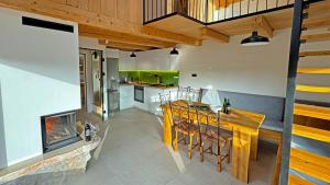 a kitchen with a wooden table and a fireplace at Boroviti Mountain House in Blidinje