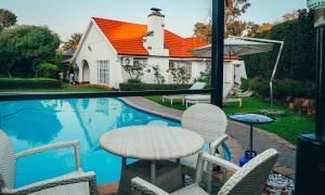 a patio with a table and chairs next to a pool at Clouds 52 Lodge in Johannesburg