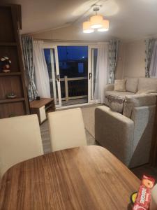 a living room with a table and a couch at Sam's Caravan Hire Coastfield Holiday Village Ingoldmells in Ingoldmells