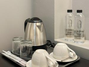 a coffee maker on a table with glasses and bottles at Lune bangkok in Bangna