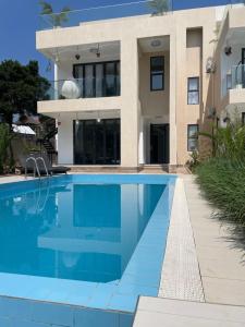 a swimming pool in front of a house at Infinity Villas 1 Superking bed Studio Apartment free parking , WiFi , 24 hr security in Entebbe