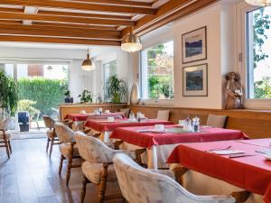 a restaurant with red tables and chairs and windows at Pension Chalet Andy in Schenna