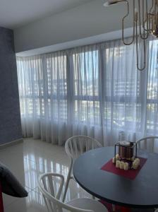 a dining room with a table and chairs and a window at Arte Plus Homestay Condo in Kuala Lumpur