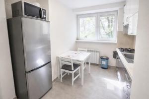 a kitchen with a white table and a refrigerator at Apartment Katamaran in Krakow +22 photos