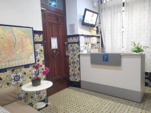 a room with a counter and a table with flowers at The Cathedral Hostel in Murcia