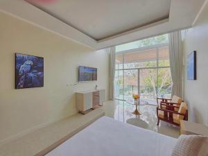 a bedroom with a bed and a large window at Ta Yai Beach Resort in Pattaya
