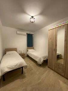 a bedroom with two beds and a dresser and a mirror at Xagħra Lodge in Xagħra +2 photos