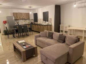 a living room with a couch and a table and a kitchen at Xagħra Lodge in Xagħra