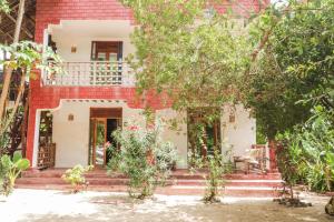 a house with stairs and trees in front of it at Karibu Maisha Lodge in Kizimkazi