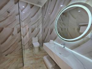 a bathroom with a mirror and a sink and a toilet at Ta Yai Beach Resort in Pattaya +20 photos