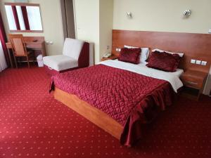 a hotel room with a large bed and a chair at Motel Aleksandar in Pojate