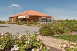 uma casa com muitas flores à frente dela em Pressoir Hôtel em Saint-Calais