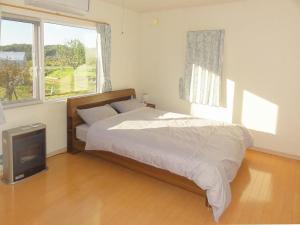 a bedroom with a bed and a television in it at Hillview cottage Sanfurano in Kami-furano