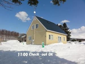 a house in the snow in front at Hillview cottage Sanfurano in Kami-furano