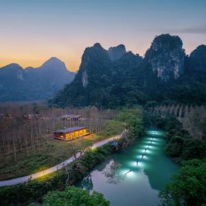 a train traveling down a river with mountains in the background at Blue Diamond Retreat in Vực Trô